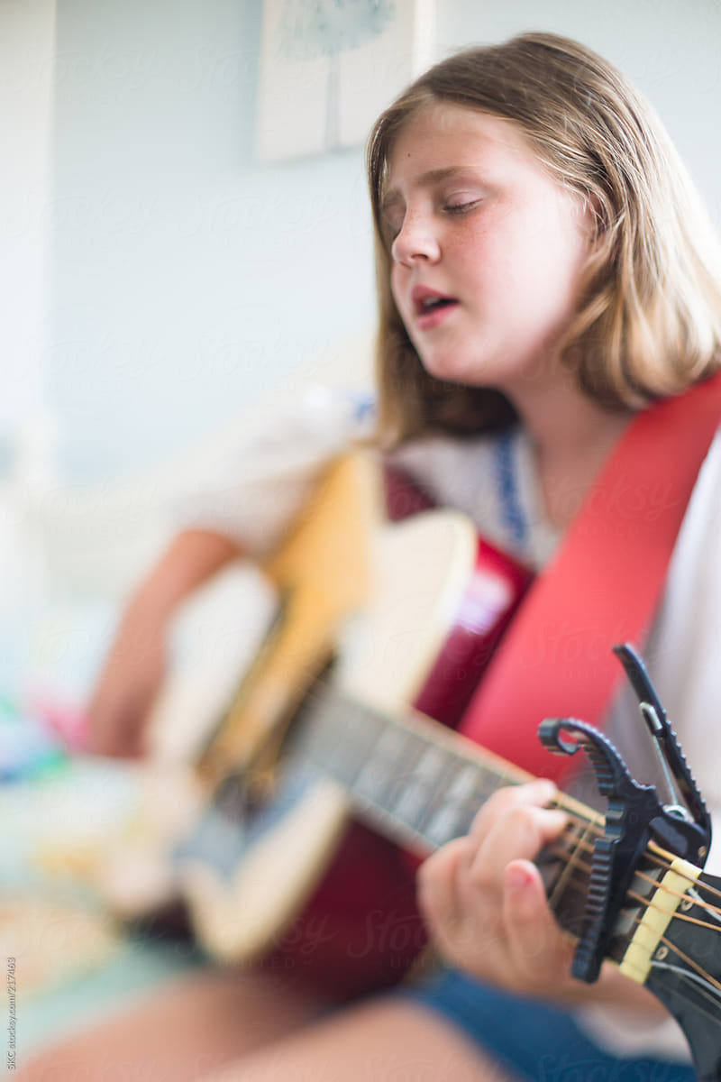 Girl Practicing her Guitar and Singing in her bedroom