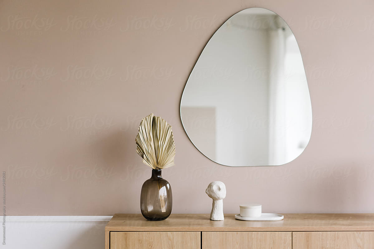 Mirror and wooden cabinet with decorative elements in room