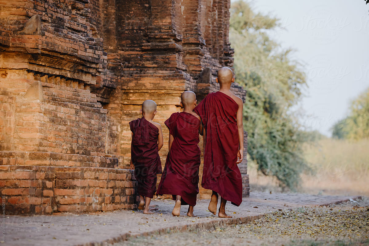 Novice monks walking by ancient pagoda