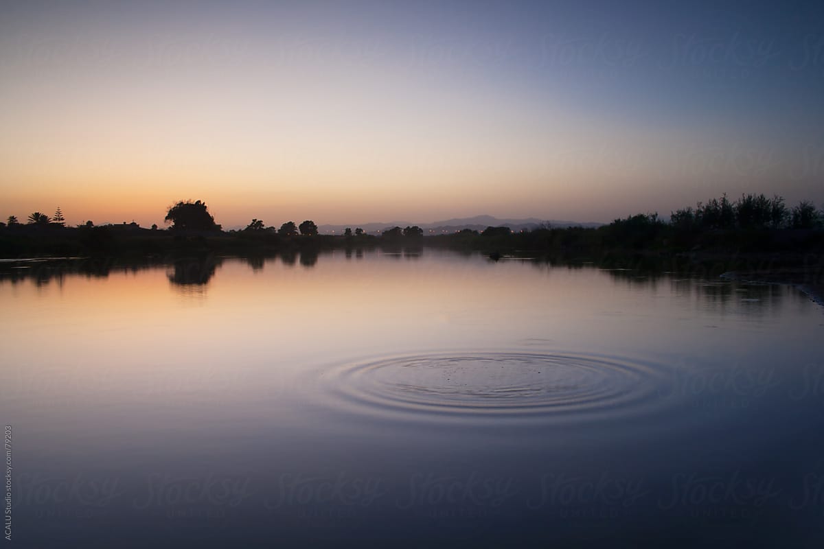 Circles in the water of a river at sunset