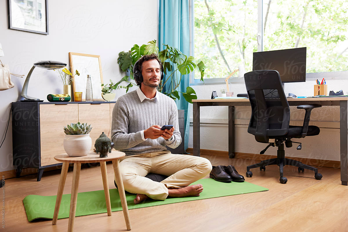 Relaxed businessman listening to meditation in office