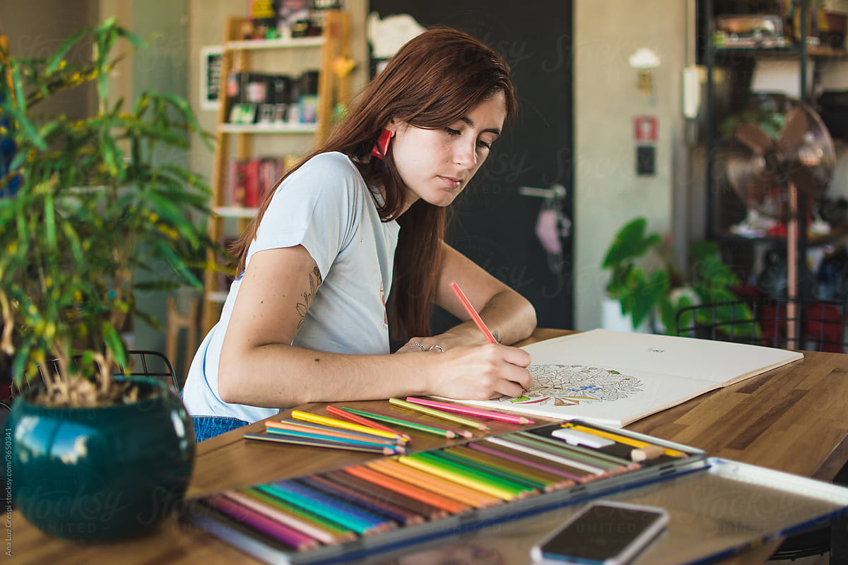 Young woman coloring at home