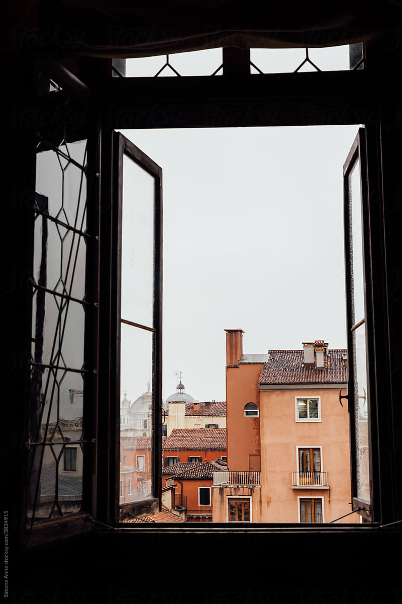 Pink buildings visible through a window in Rome, Italy