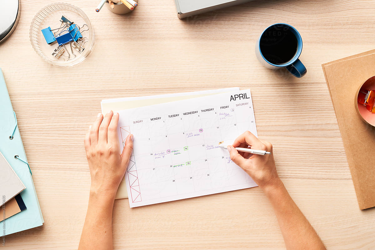 Unrecognizable Person Making Notes In Calendar PorMart Sans
