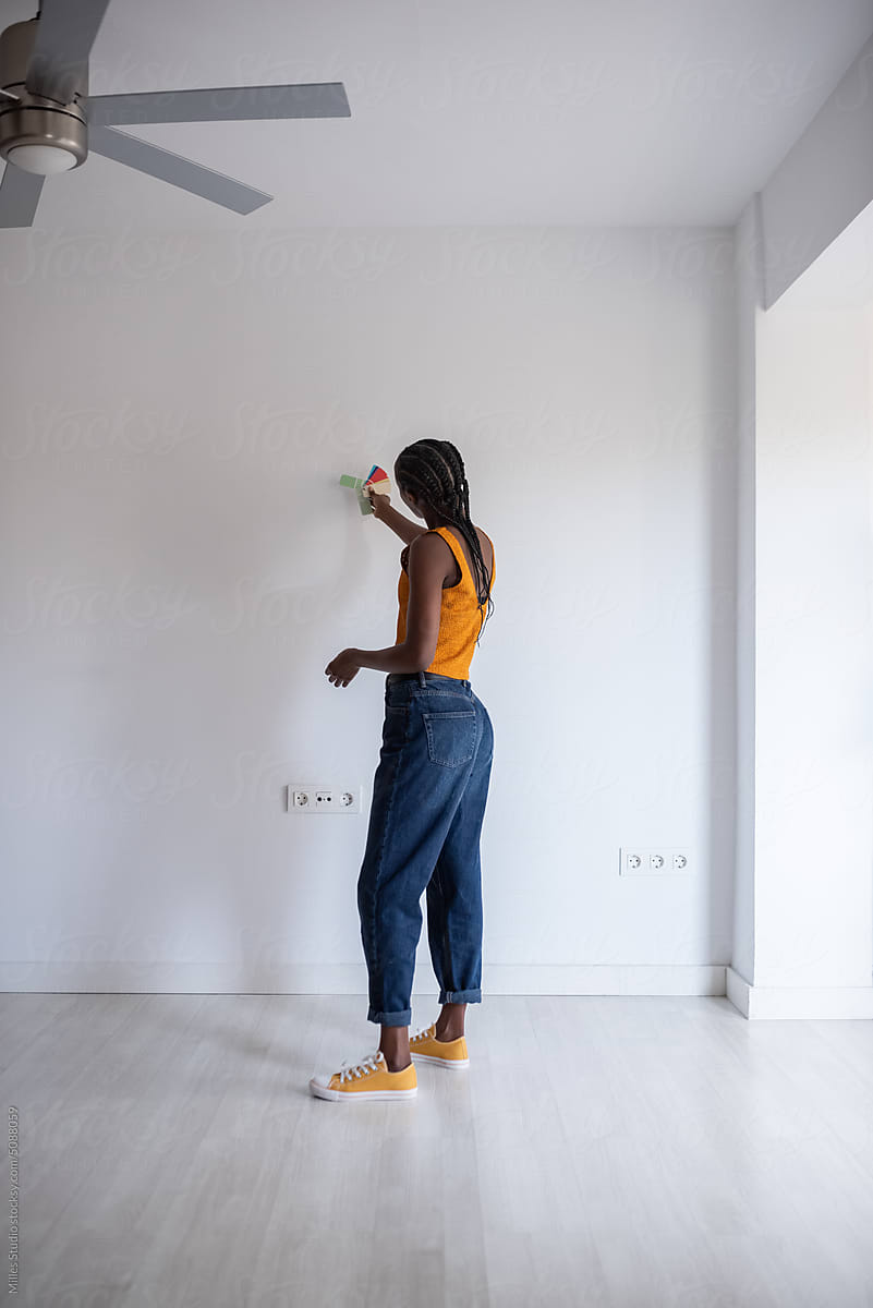 African American woman selecting paint color for wall