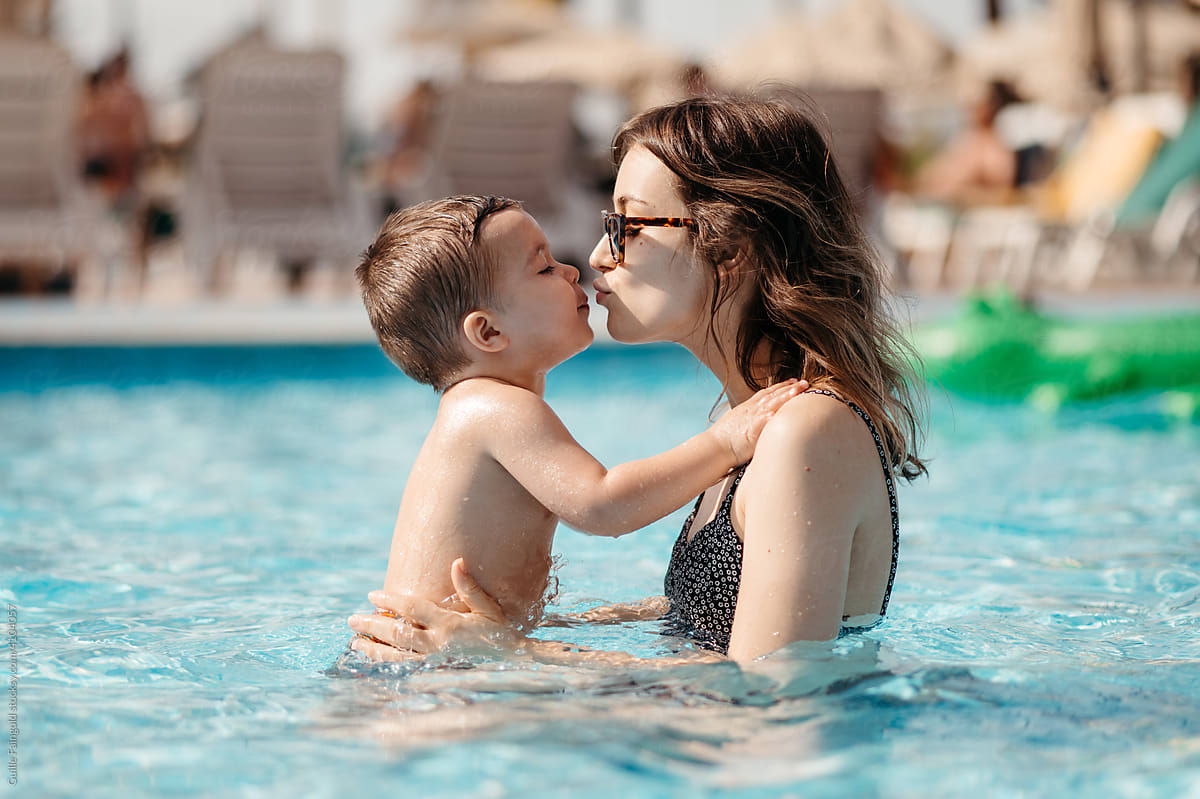 Woman kissing son in pool