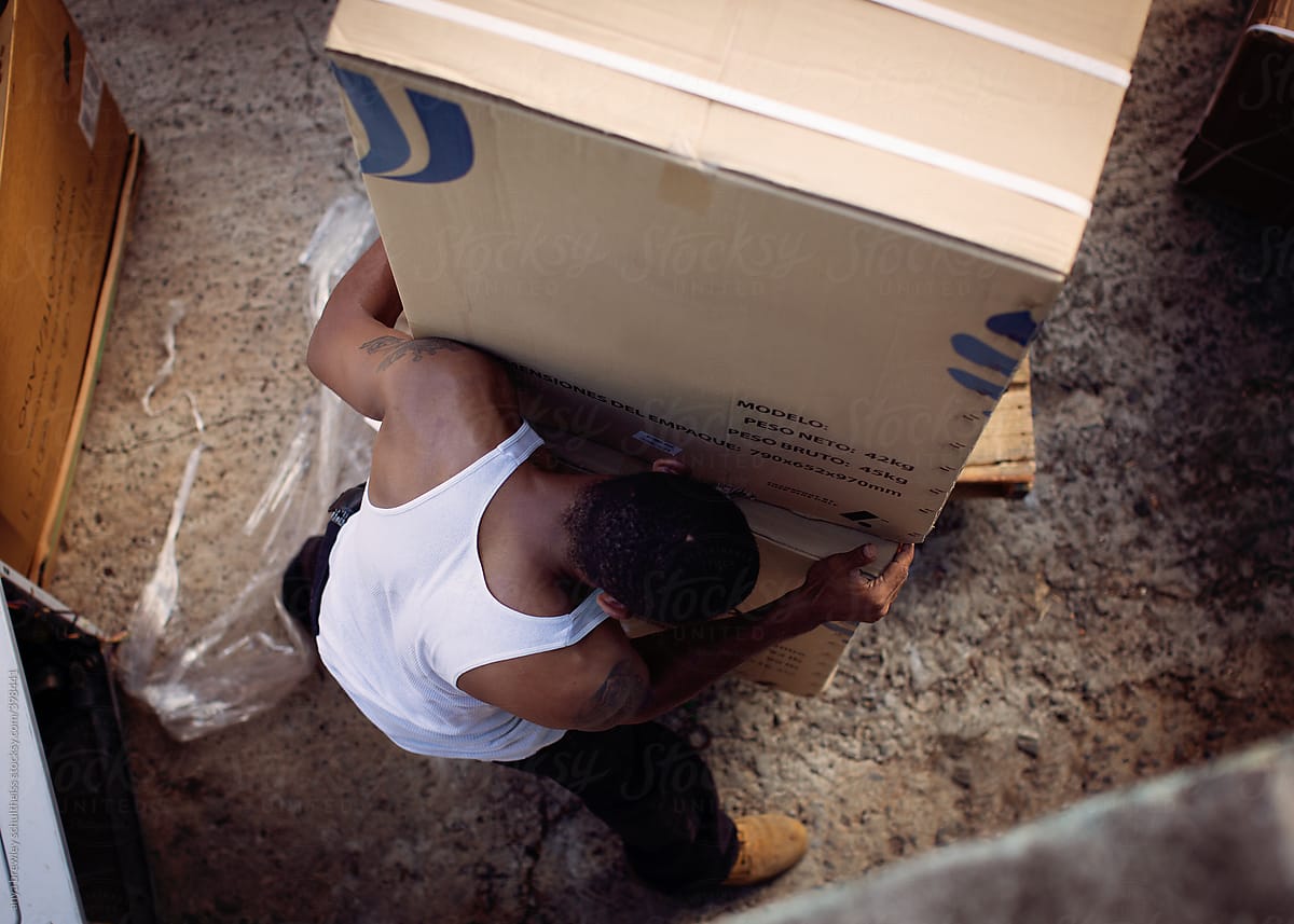 Portrait of a man pushing and moving boxes