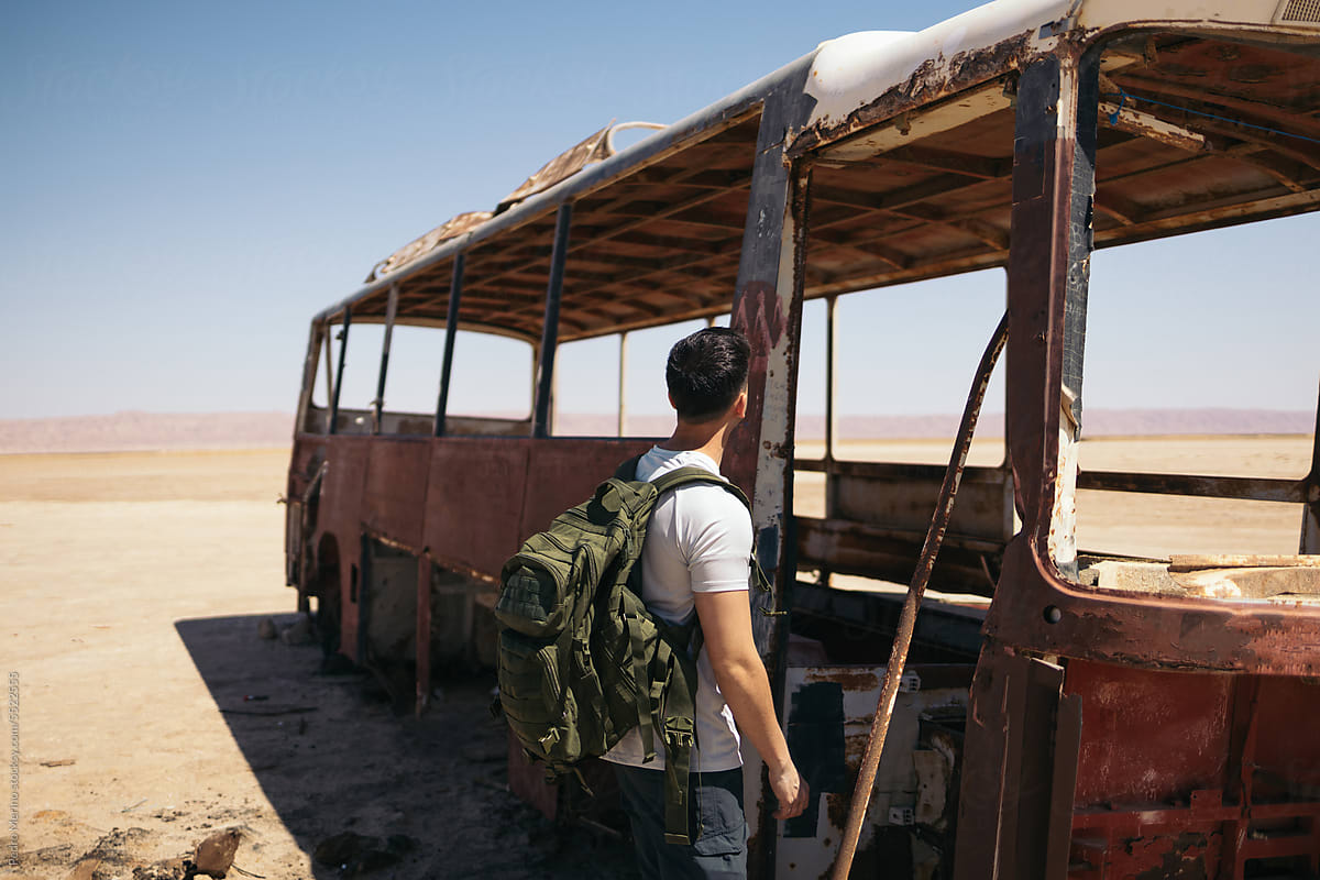 Man in an abandoned bus in the Sahara desert