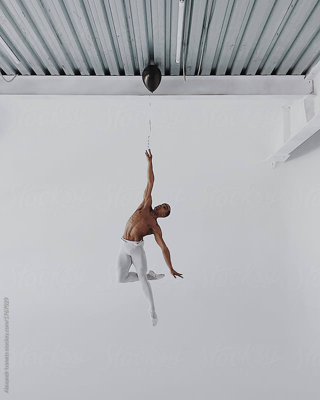 Ballet dancer jumping high on white