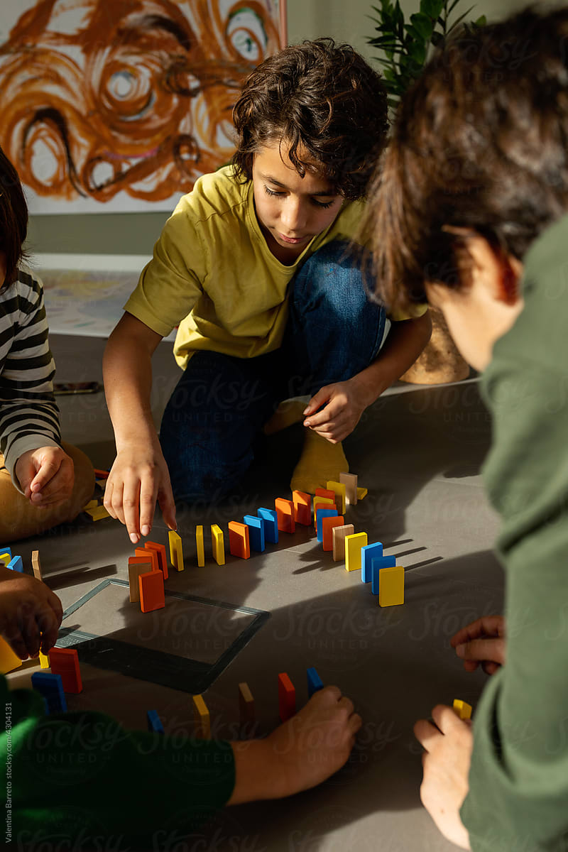Children doing circuit with colorful dominoes