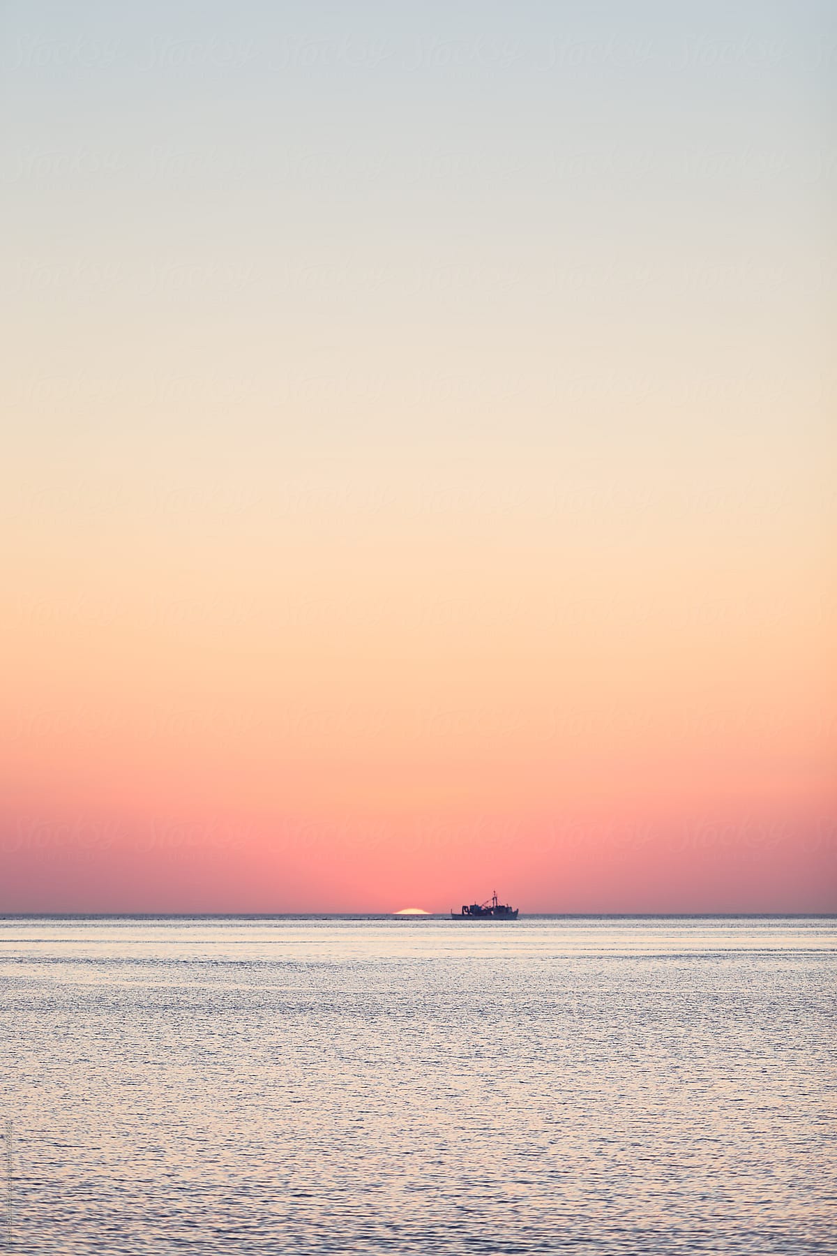 A Boat and the Sun on the Horizon at Sea