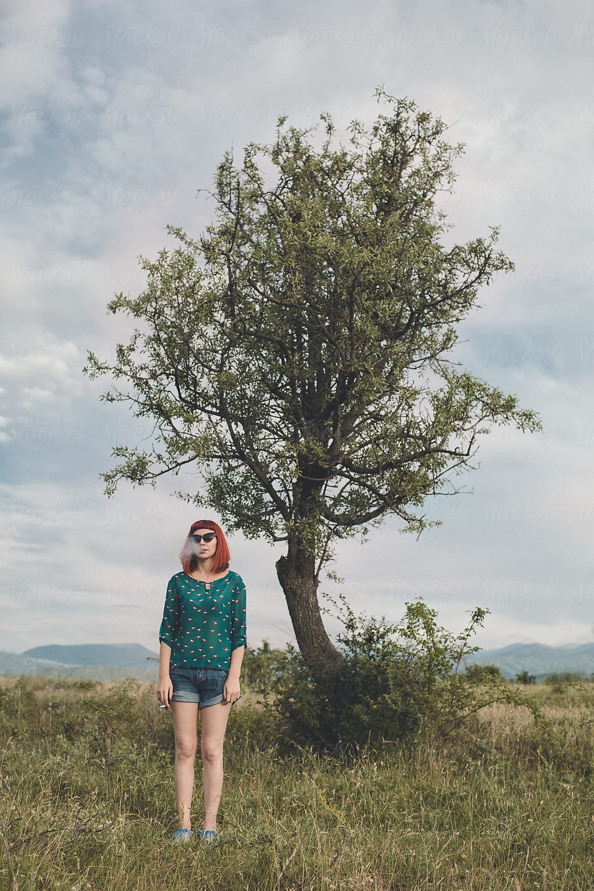 Young woman standing in front of tree
