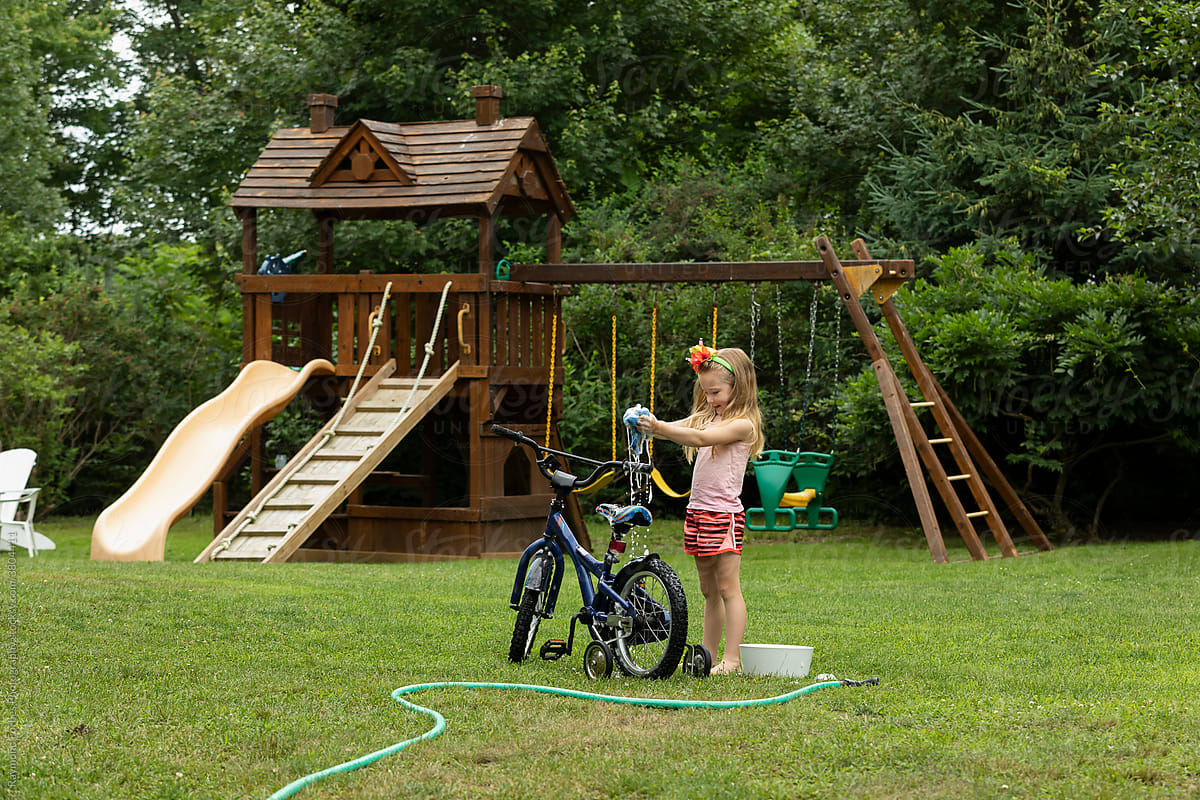Young girl Washing her bicycle in the backyard of home