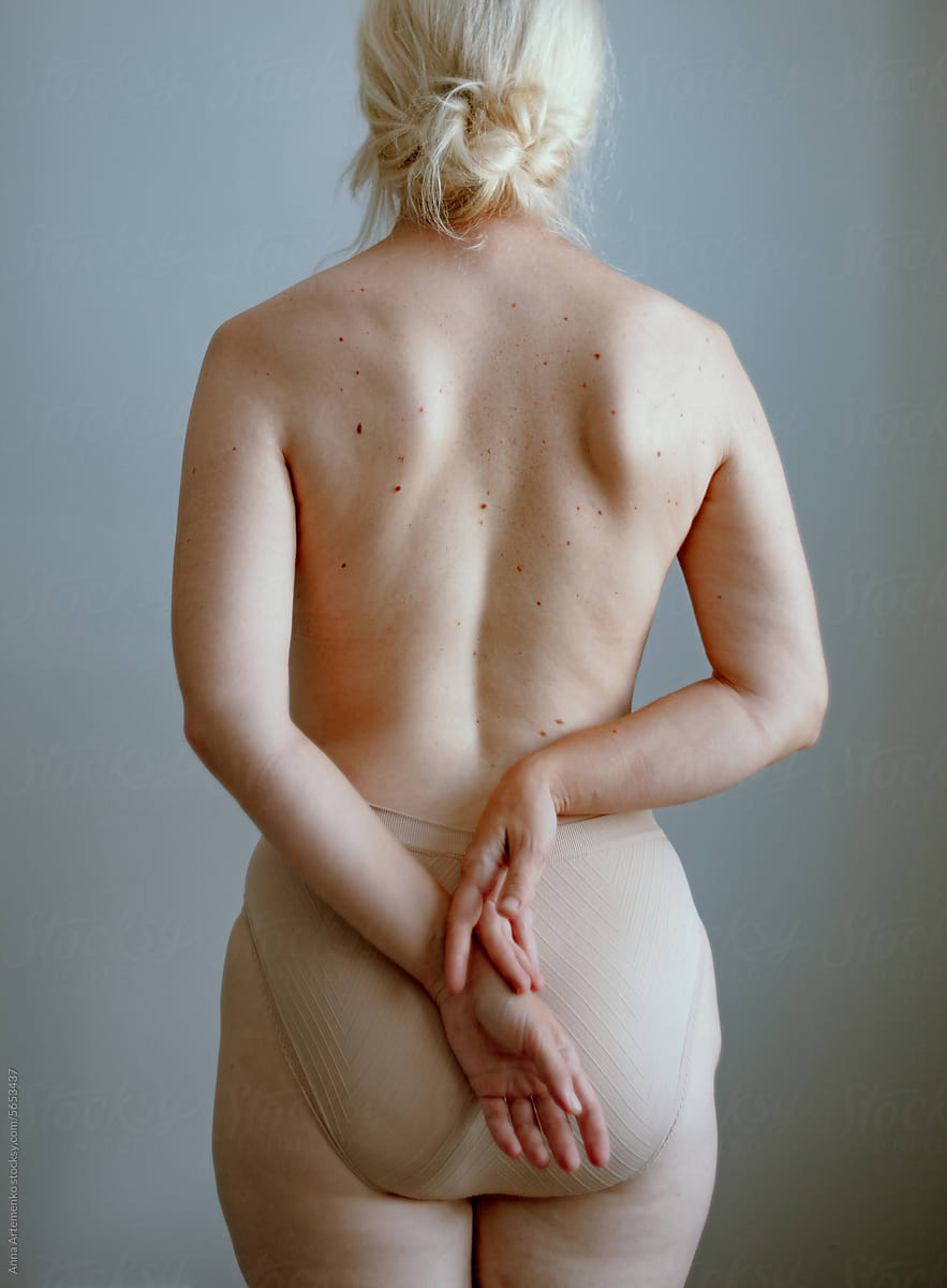 Detail of a woman\'s naked back with her hands on her back
