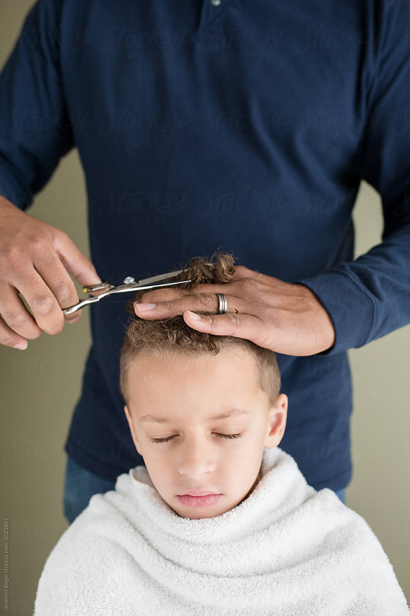 Dad cuts hair of child