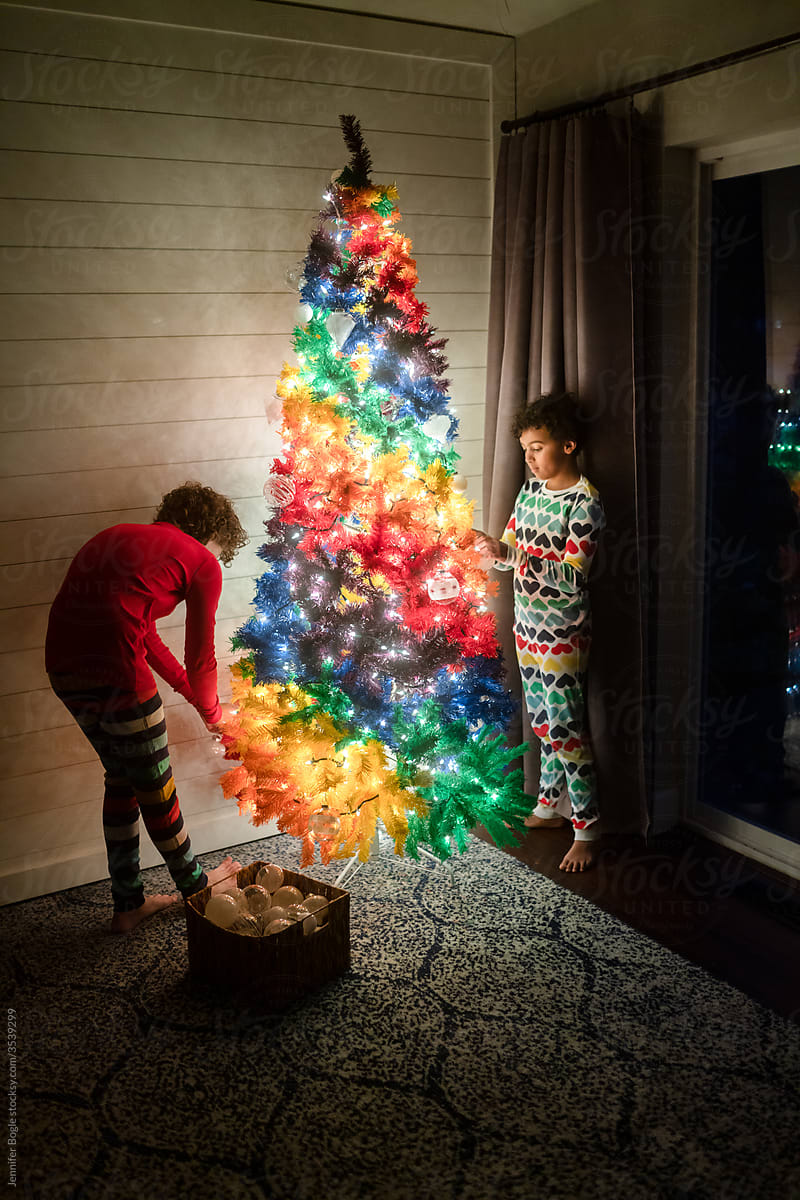 Brother and sister decorate rainbow christmas tree