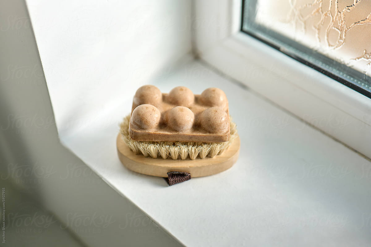 Natural bristle brush and soap on windowsill in daylight