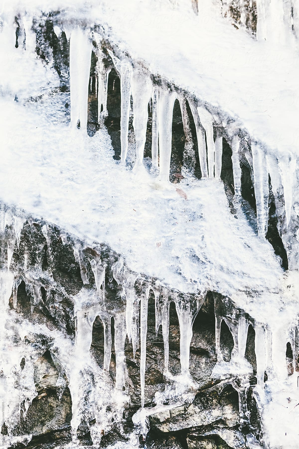 Frozen Icicles Melting on Rocks, Winter Season