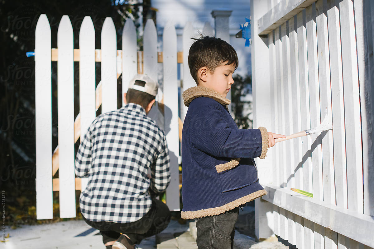 Little kid painting fence