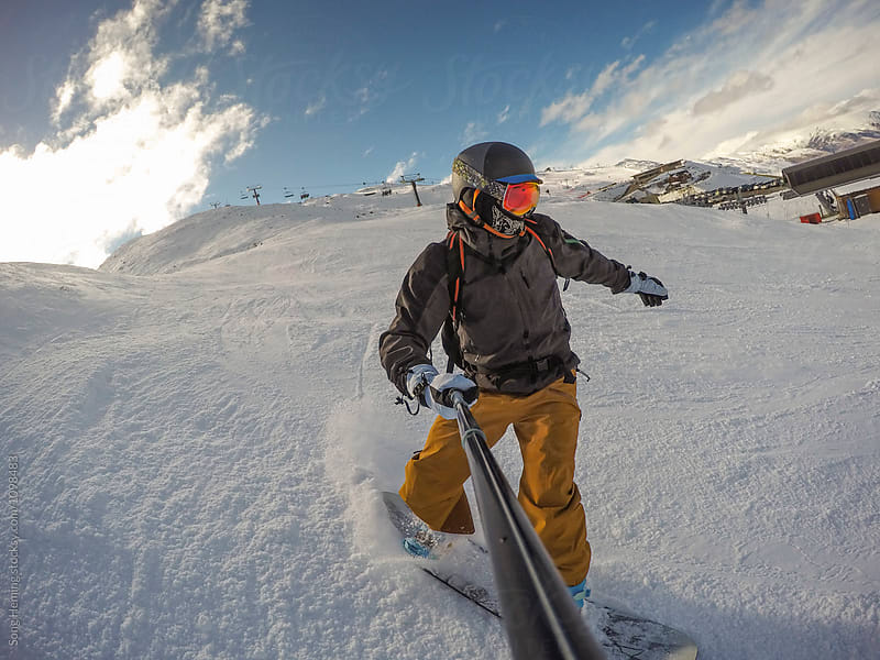 A snowboarder taking selfie photo at ski area