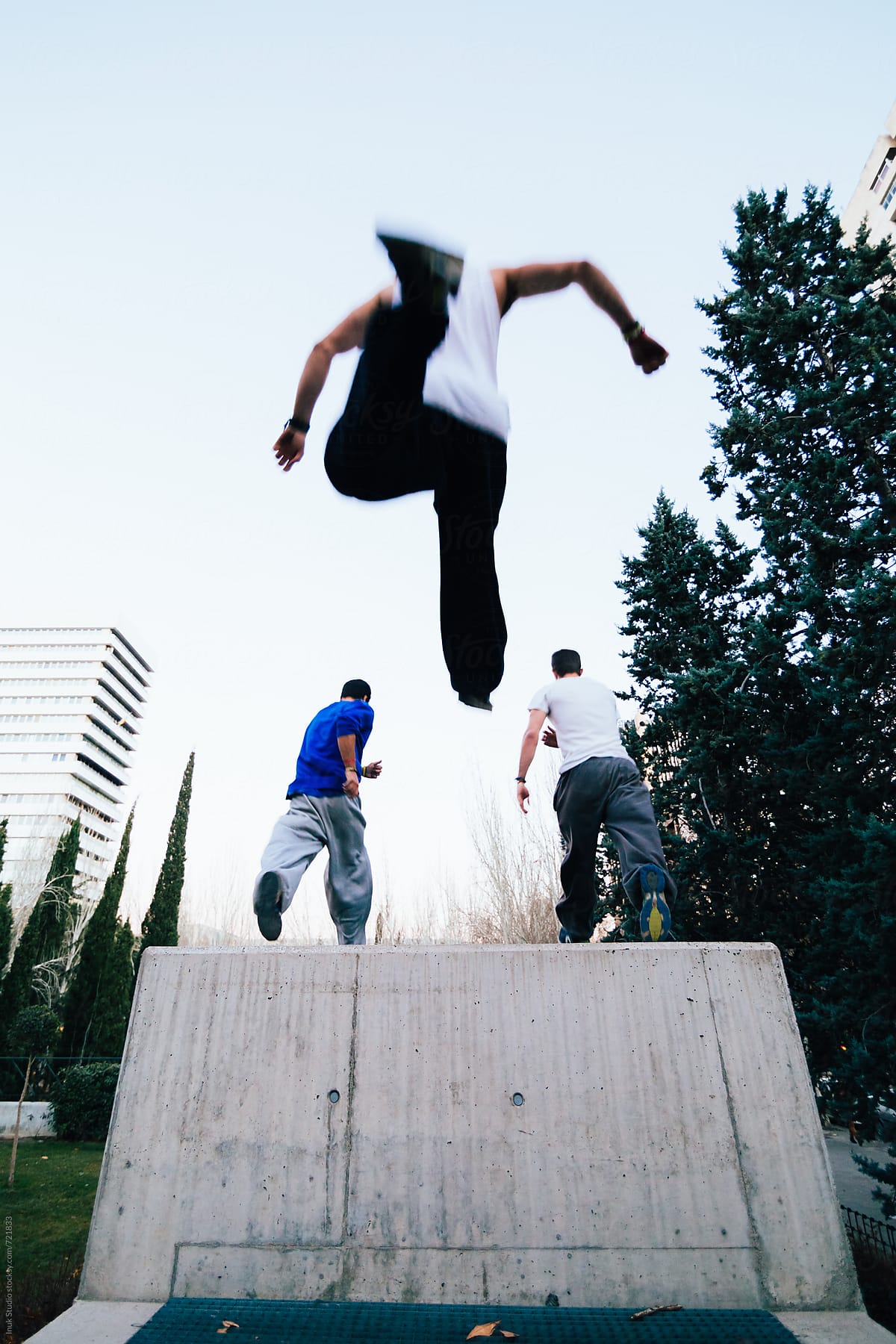 Low angle view of man jumping after his friends during parkour session on the city
