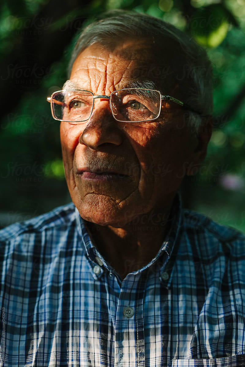 Portrait of old man in spots of sunlight