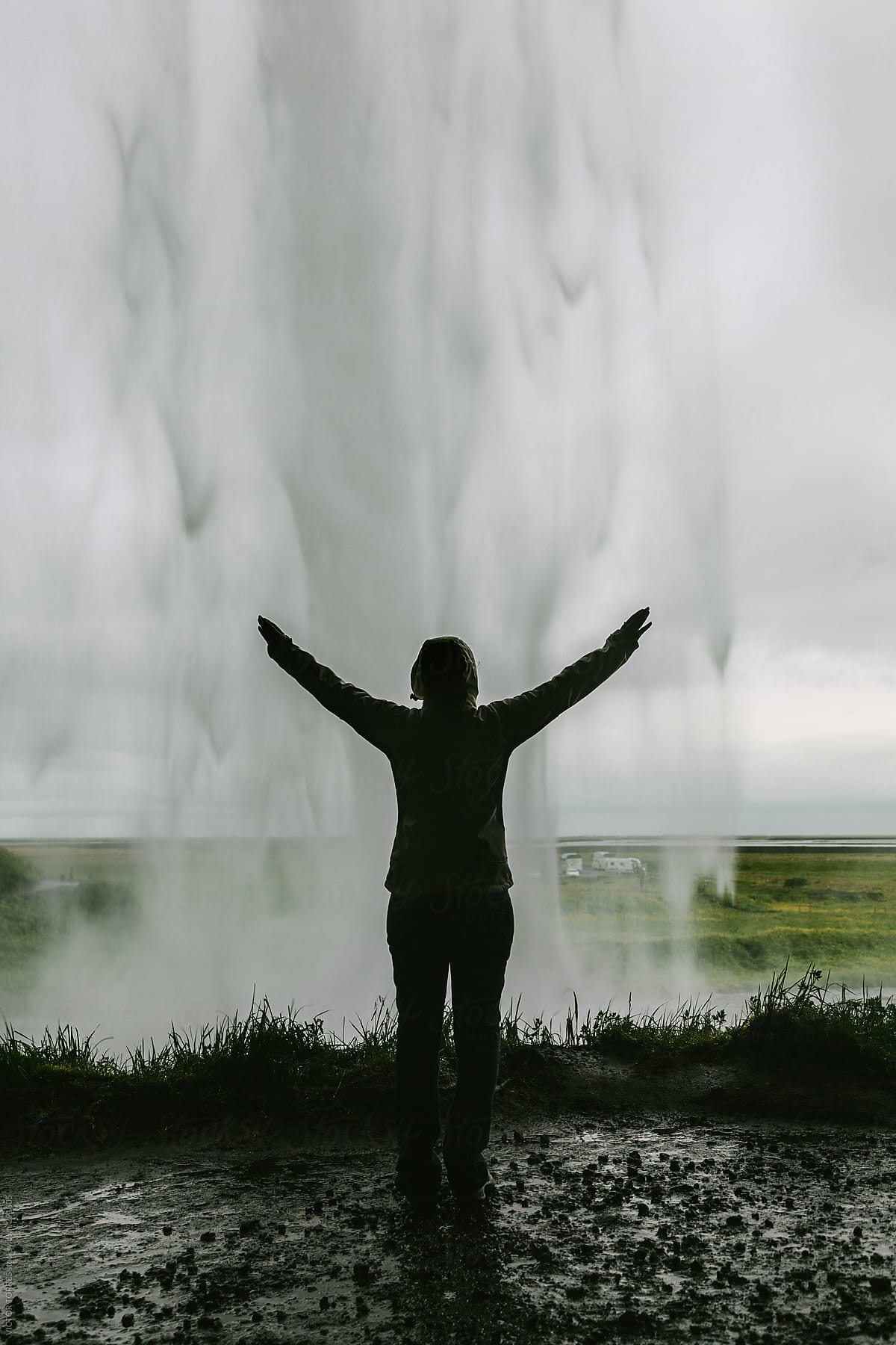 Person with Arms Wide Open inside the Seljalandsfoss Waterfall, Iceland