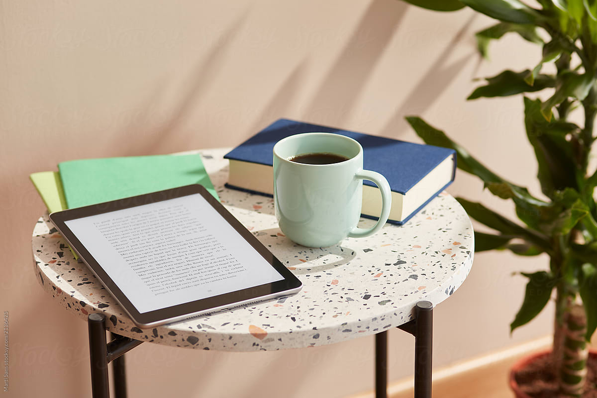 Ebook and cup of coffee on marble table.