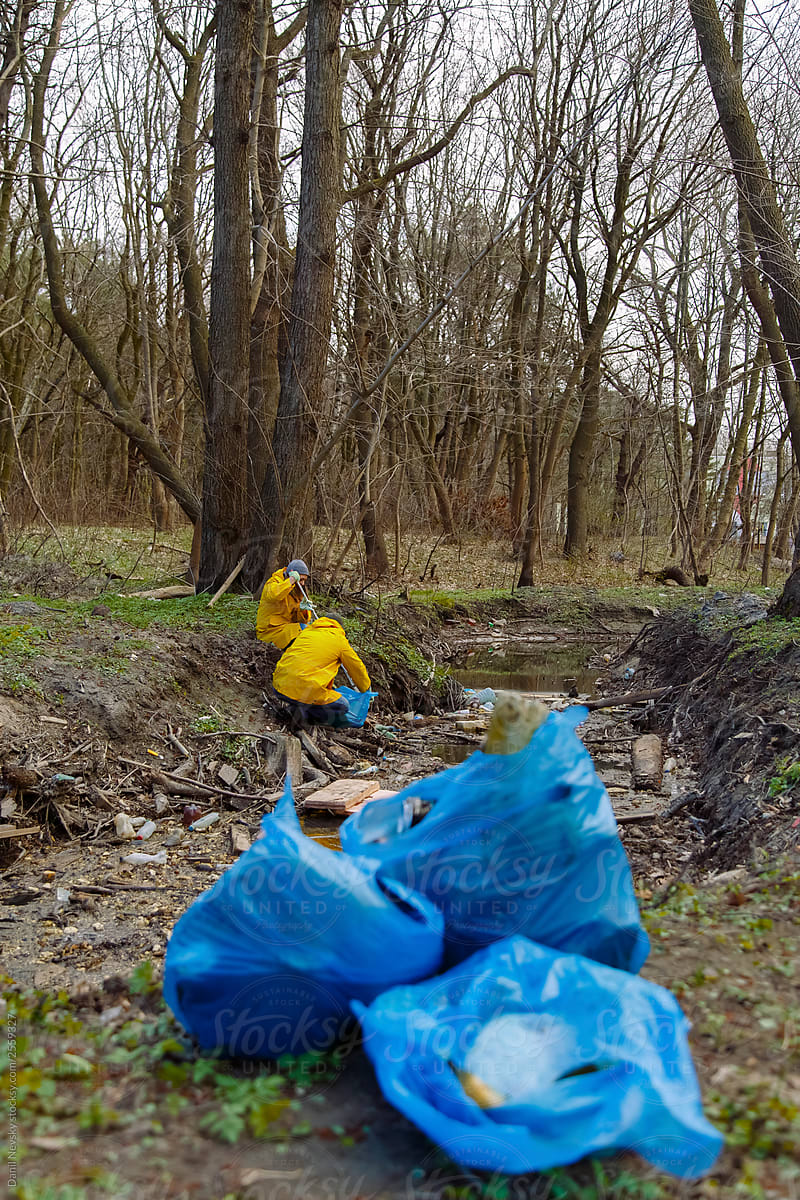 Big blue bags with plastic garbage in forest