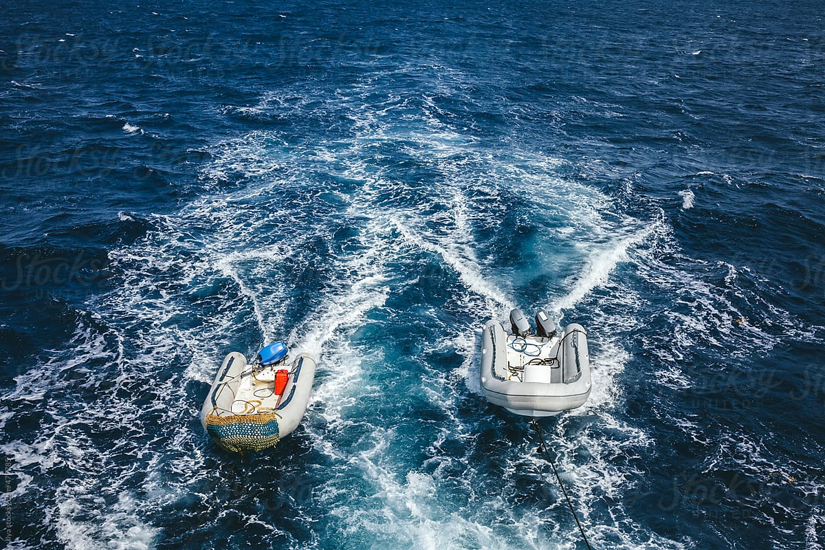 Two empty powerboats sailing on the Red Sea tied to the ship
