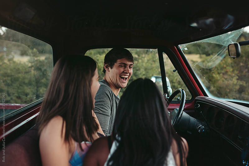 Young friends enjoying summer road trip together in old truck