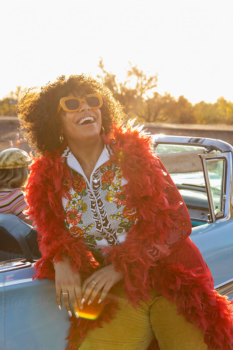 Black  Woman next to Vintage American car with big smile