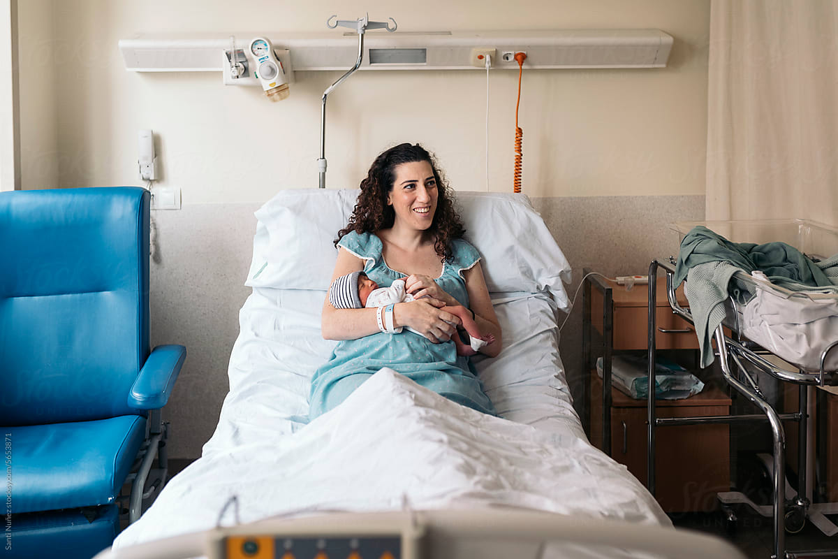 Mother Breastfeeding Newborn In Hospital room
