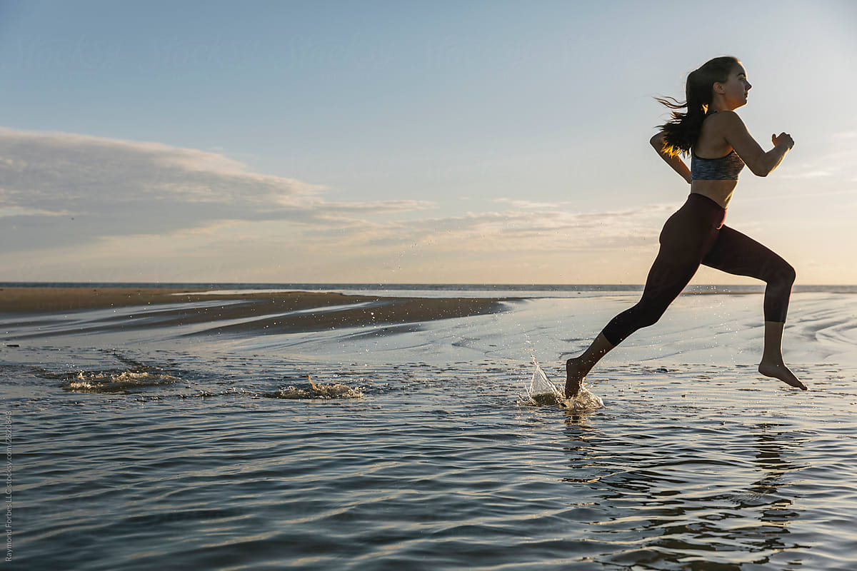 Beautiful Fit Female Athlete Running On Beach By Raymond Forbes Photography