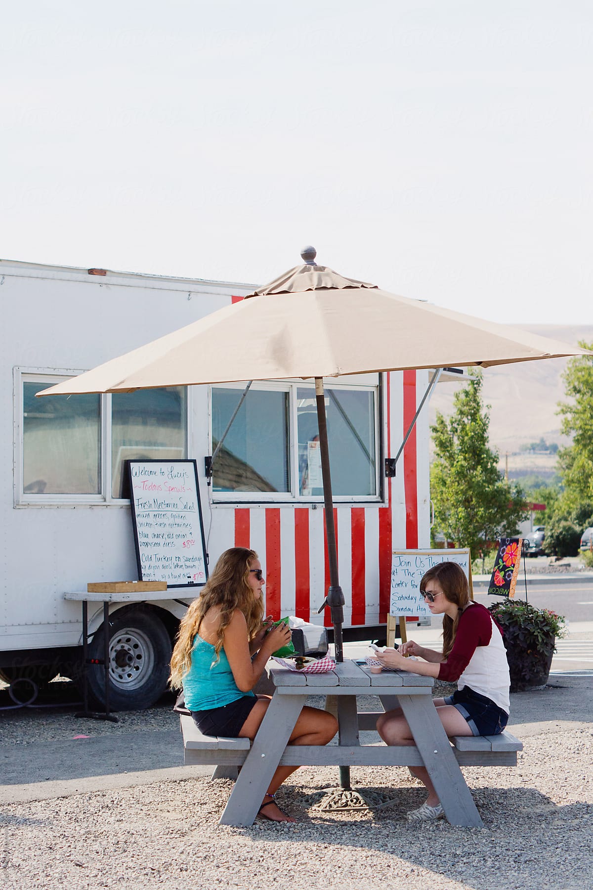 Customers sit at picnic table outside food truck
