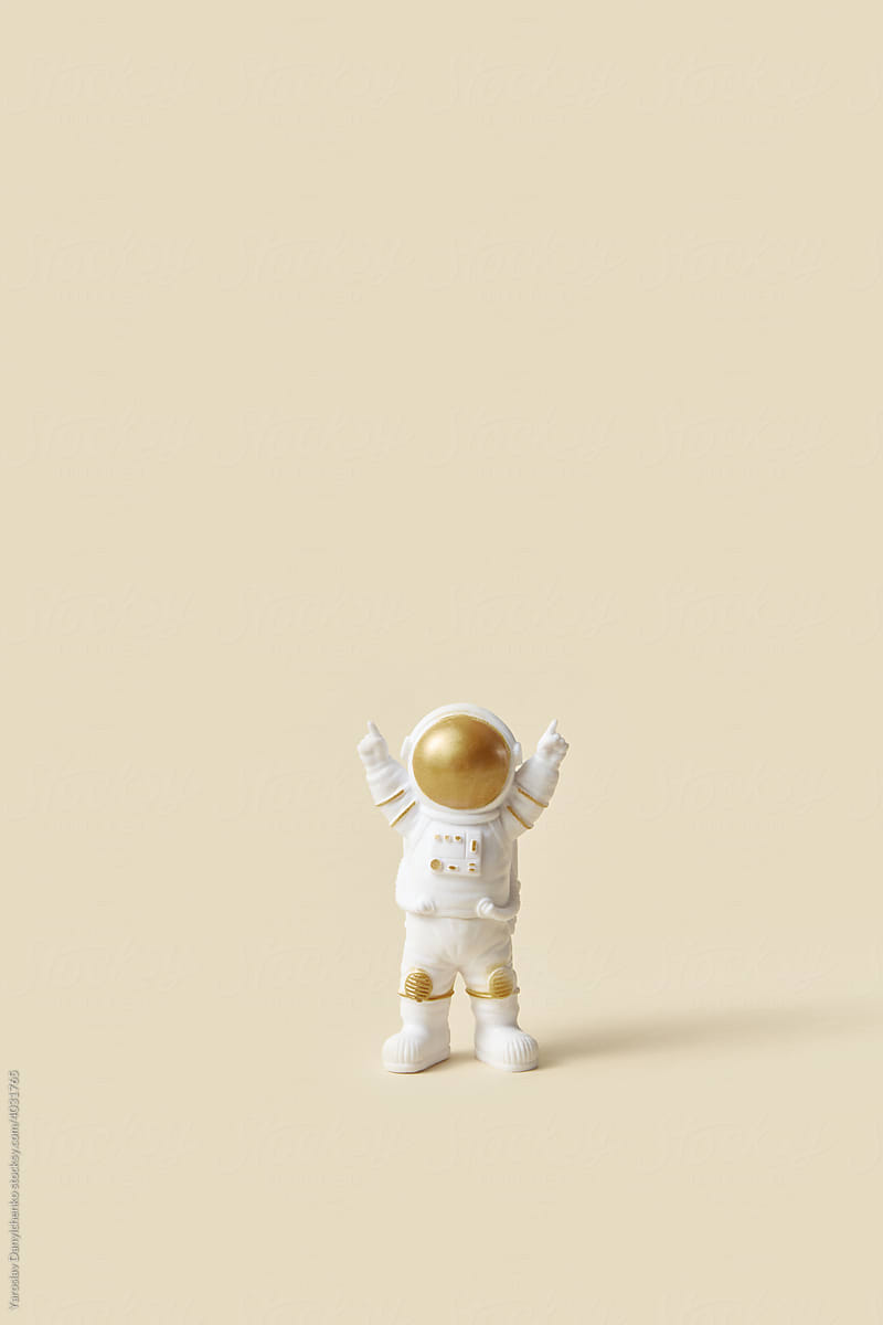Toy astronaut raising hands up