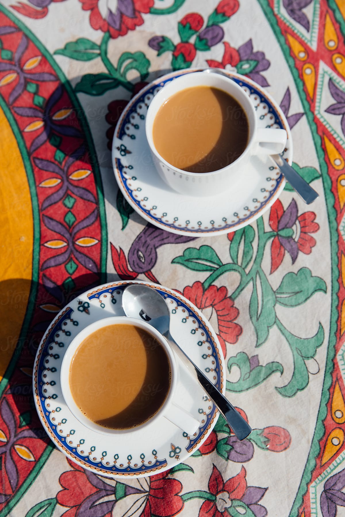 Indian tea in cups with saucers on a colorful tablecloth