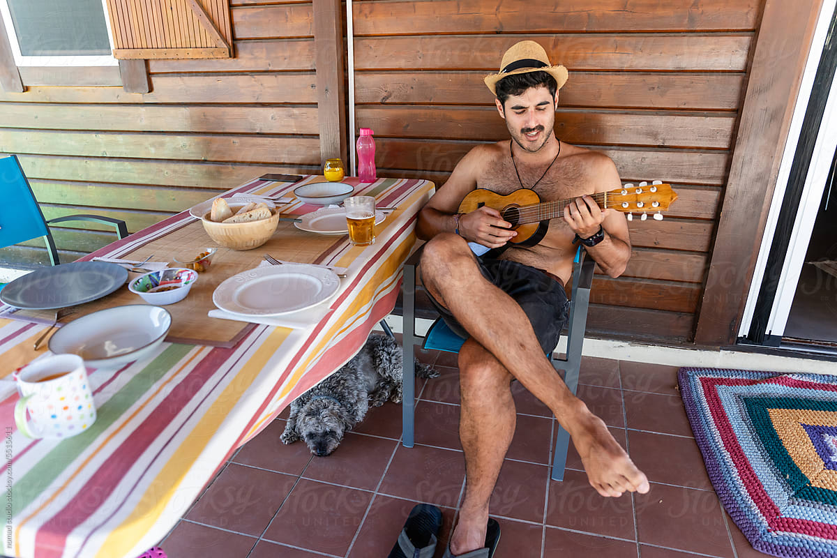 man on vacation in the countryside playing the ukulele
