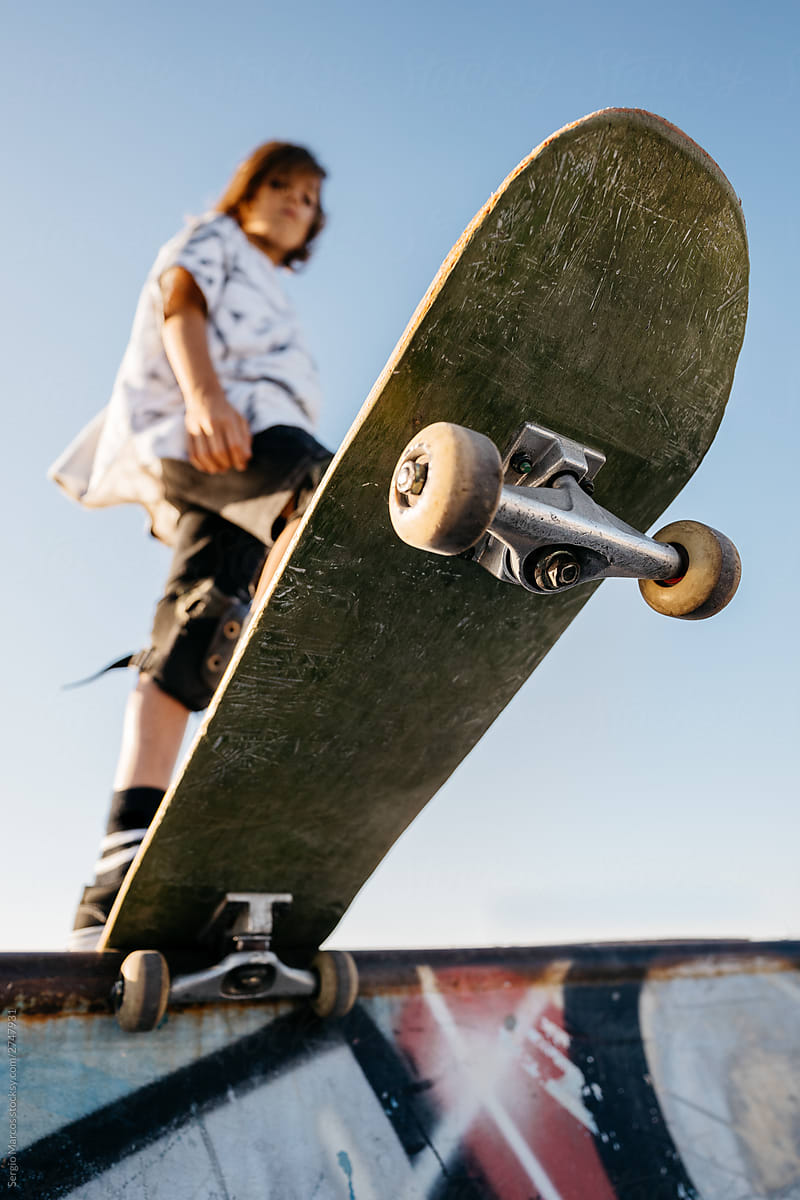 Kid with skateboard on ramp in skatepark