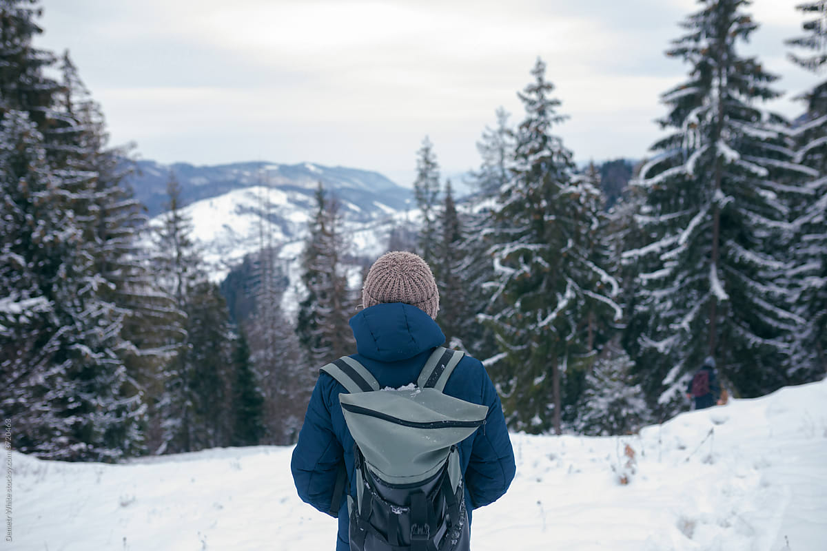 guy wearing winter clothes on the background of a mountain forest