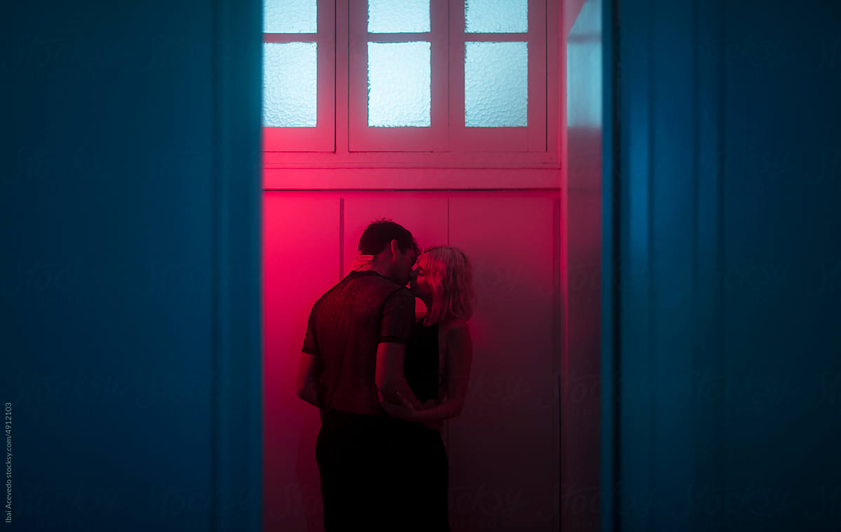 Lovers kissing with neon lighting and dreamy scenery