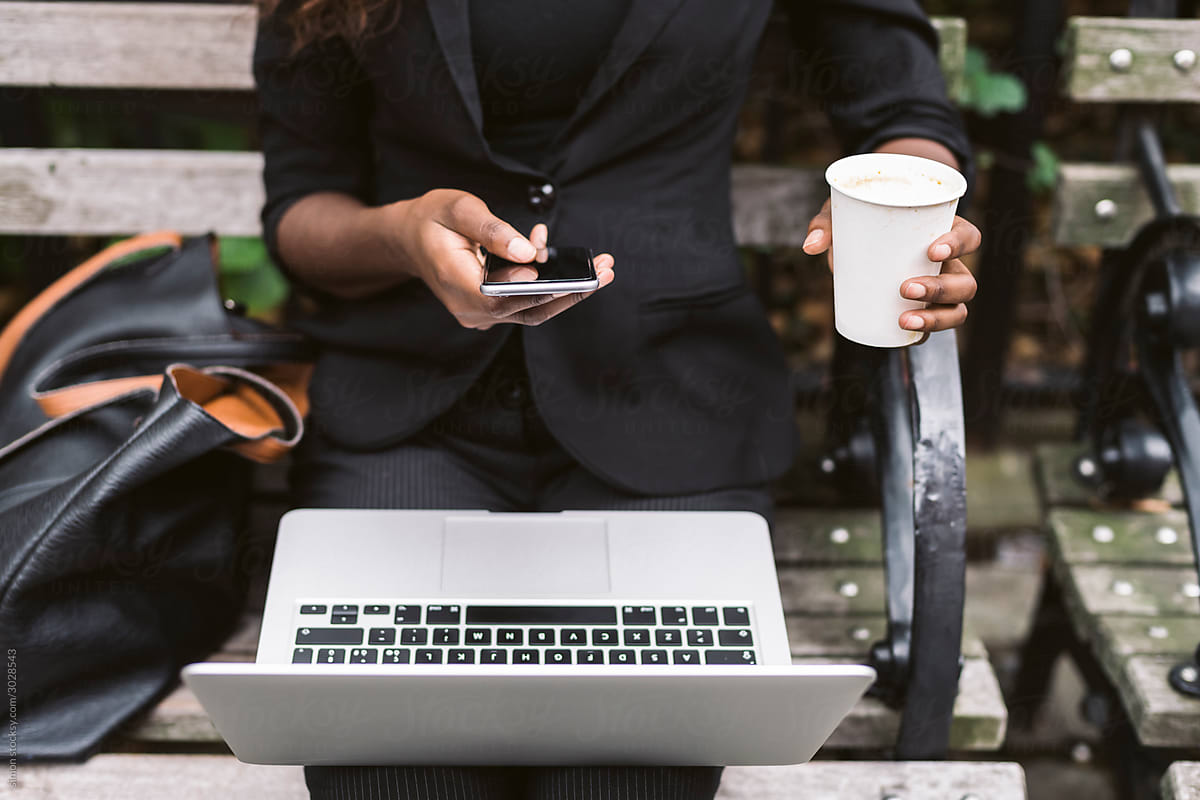 Businesswoman texting and holding coffee