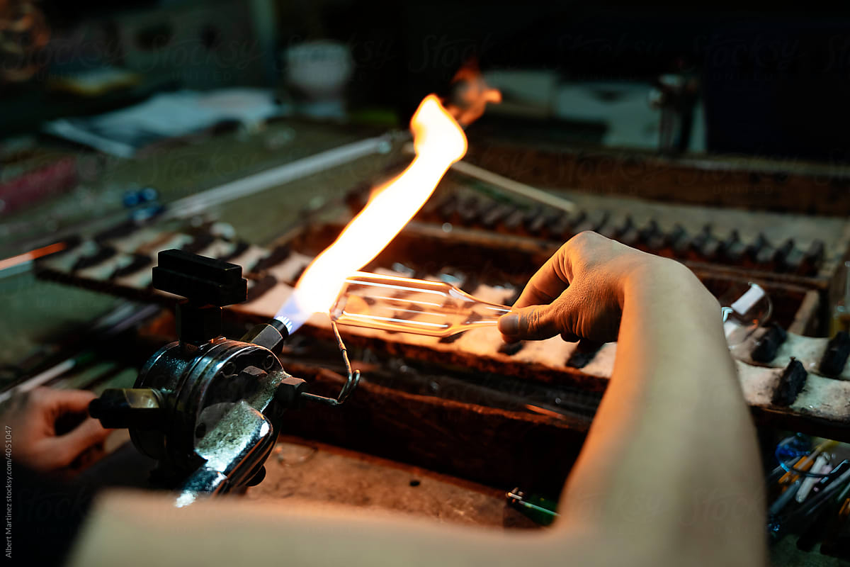 Woman glassblower working with torch flame