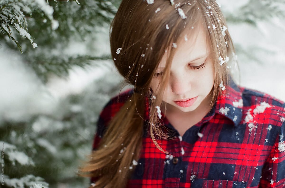 Girl in red & blue plaid flannel shirt in the snow