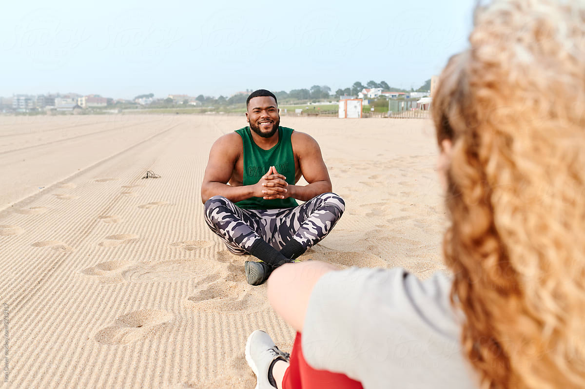 Fit man talking to a friend at the beach