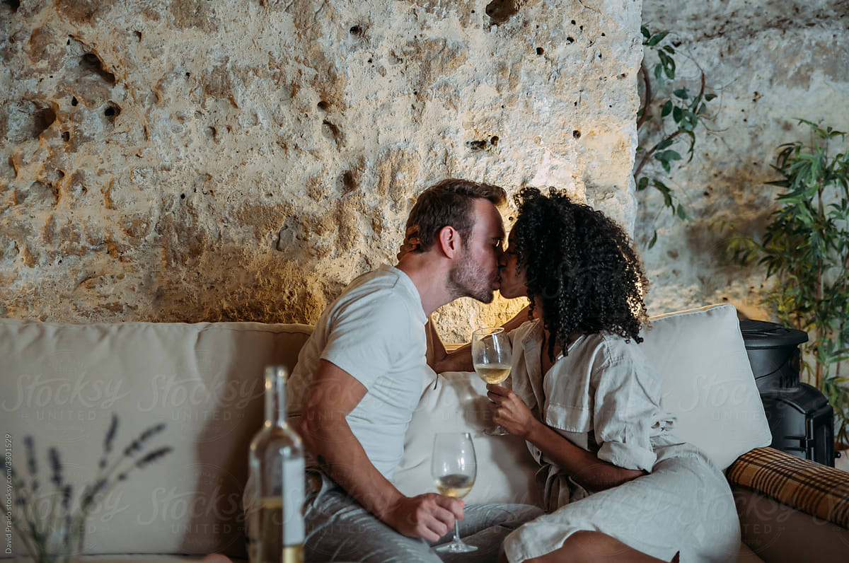 Happy couple drinking wine at home and kissing