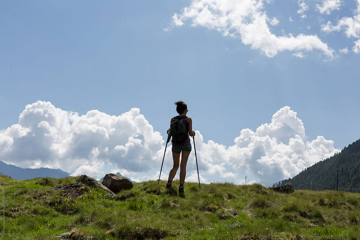 silhouette of hiker girl walking on top of the mountain.