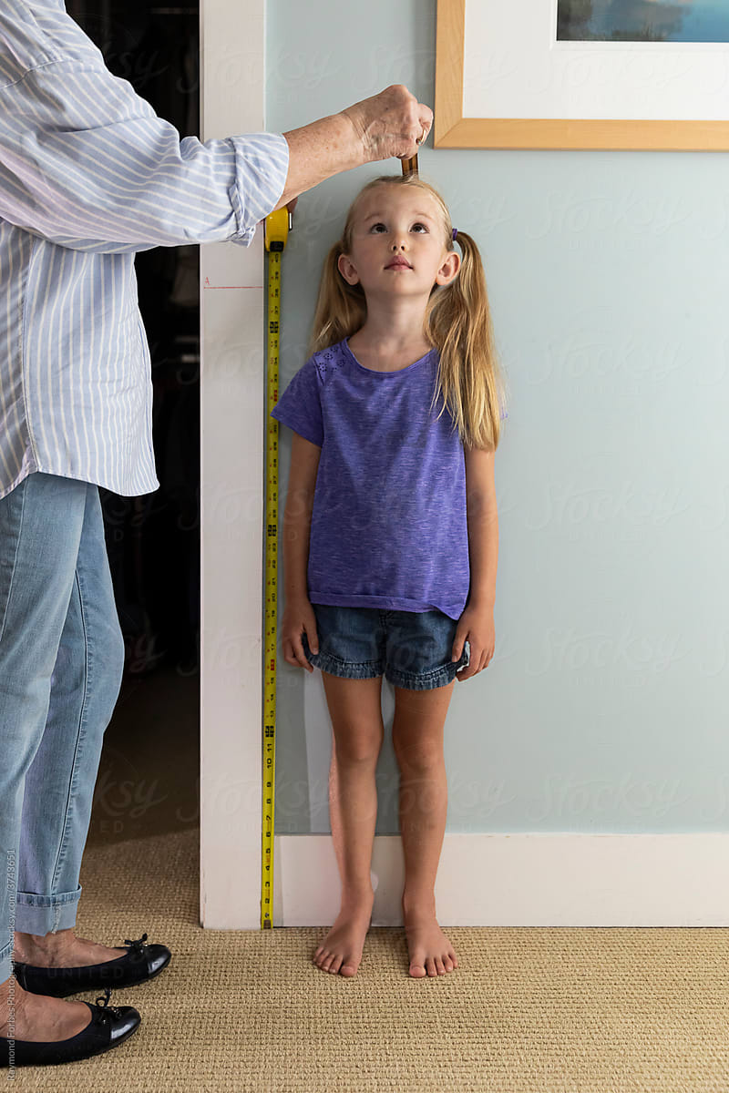 Young Girl Measuring her height Looking up