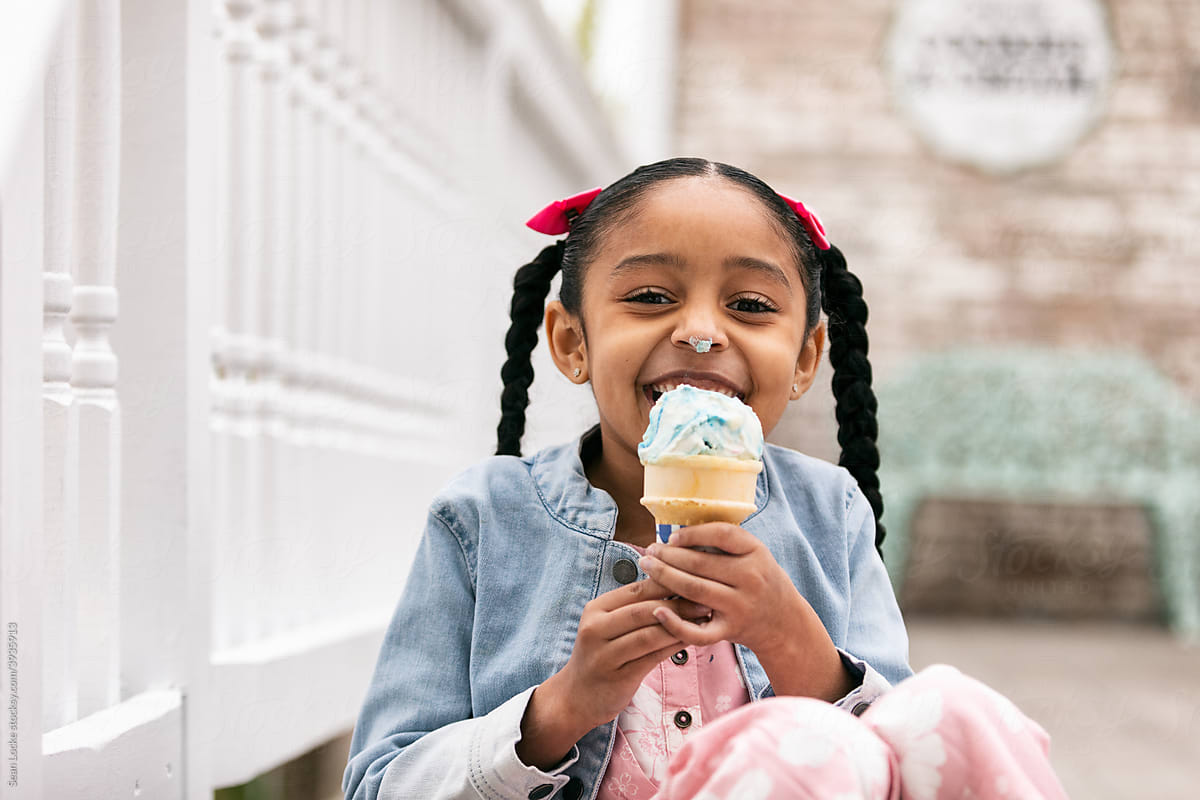 Young Girl Looks At Camera While Eating An Ice Cream Cone