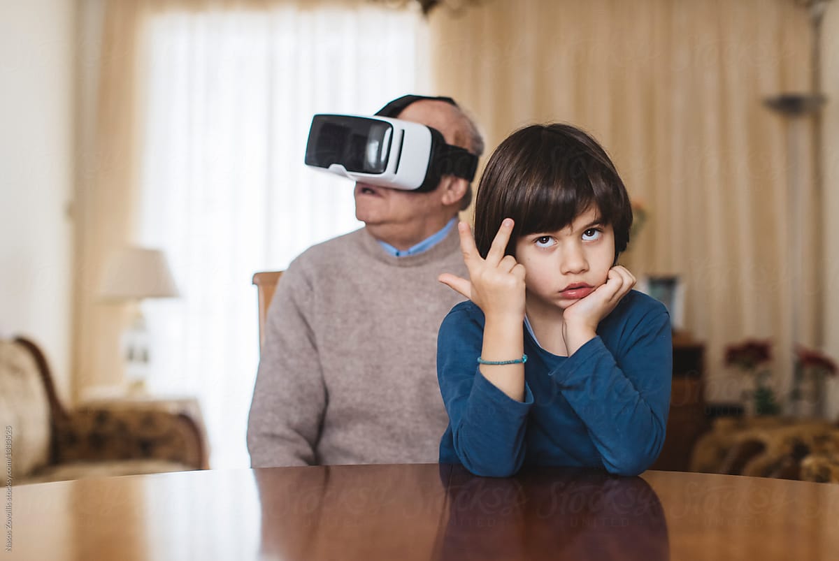 Grandfather with his grandson using virtual reality glasses